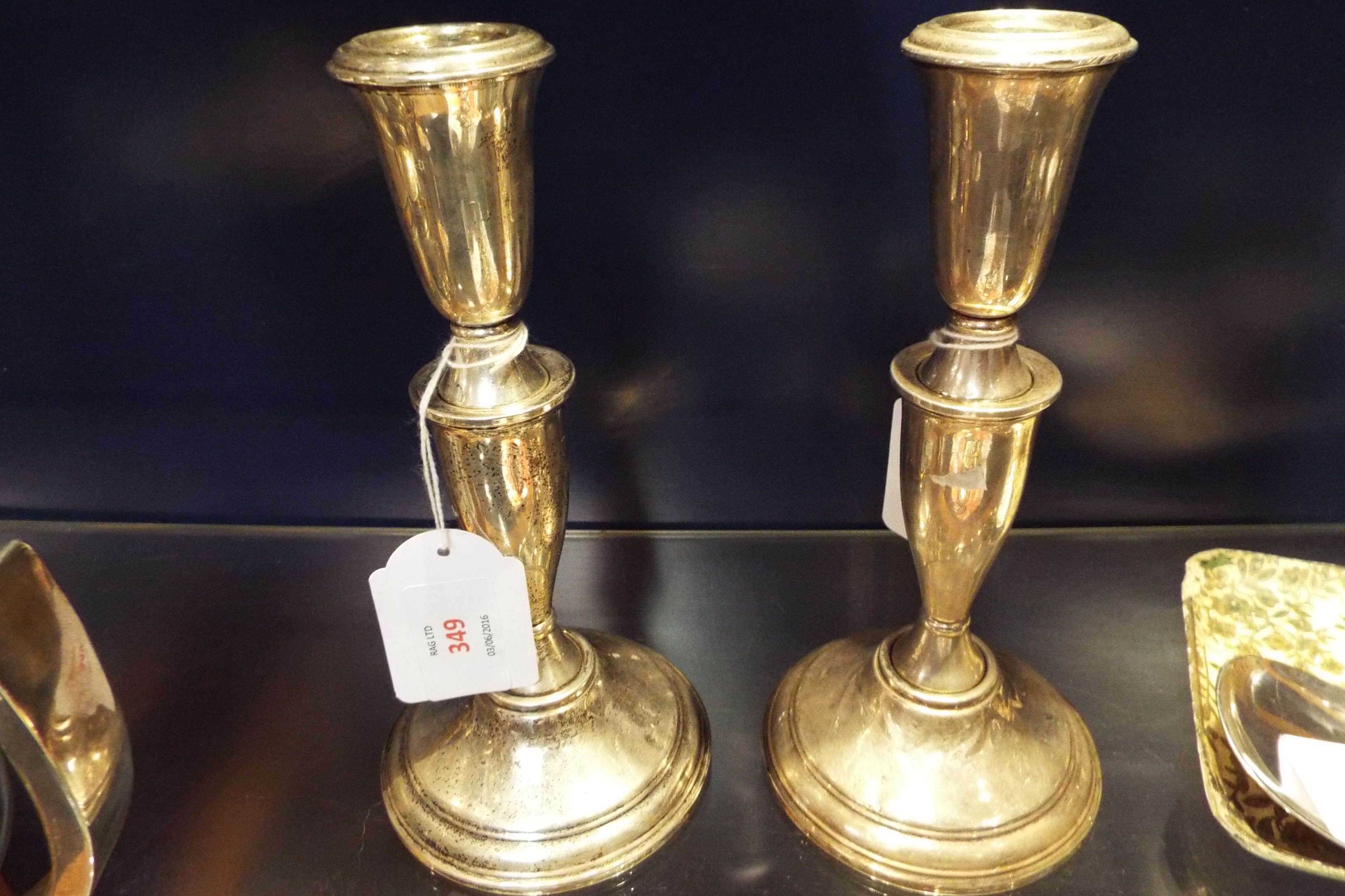 A pair of sterling silver shaped candlesticks stamped 'Crown' sterling to bases