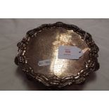 A Chester 1916 silver salver having scroll and shell scalloped rim resting on three ball feet