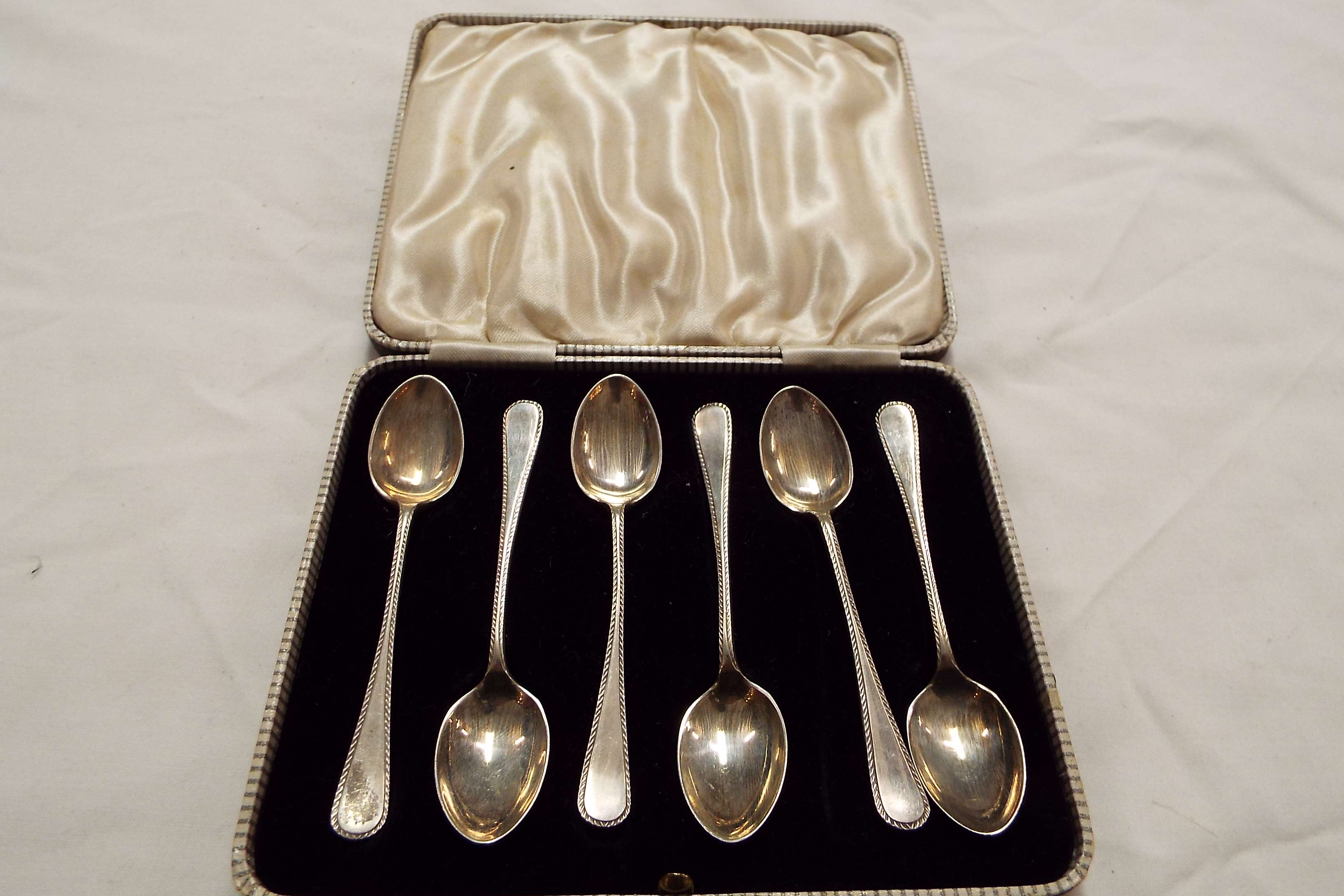 A set of cased silver tea-spoons with gadrooned borders dated Sheffield 1965