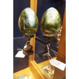 A pair of Russian style hand-painted lacquered eggs each depicting landscape scene,