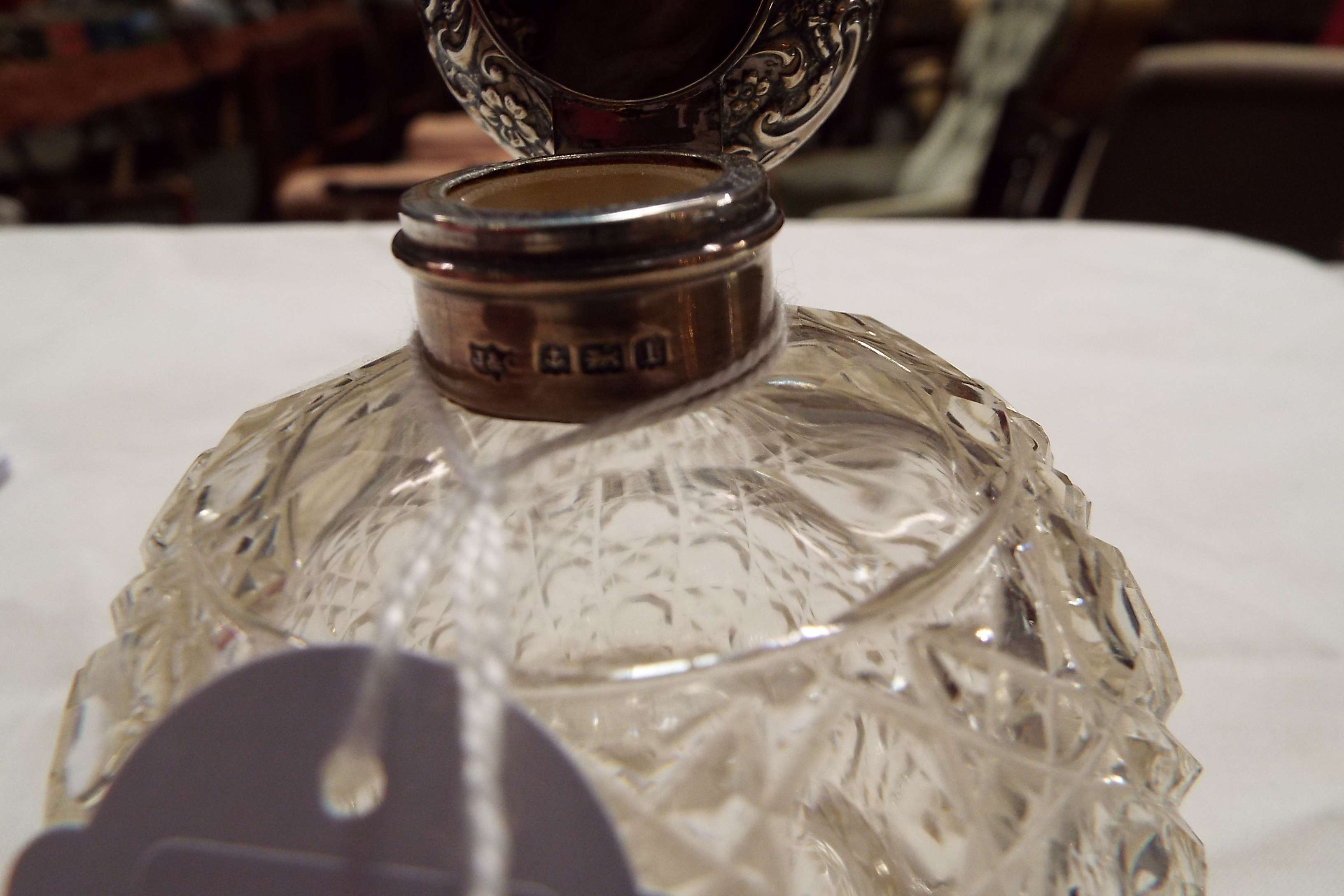 A Birmingham 1910 silver topped perfume bottle having embossed scroll decoration with hob-nail cut - Image 3 of 3