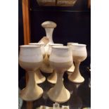 An Iden pottery cream and buff ground decanter of bulbous form with six matching goblets