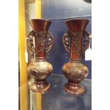 A pair of Chinese bronze twin handled vases moulded in relief with birds amongst blossoms