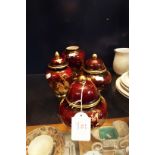 Three Carlton-ware Rouge Royale lidded urns and a vase with floral and peacock decoration