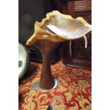 A wooden art sculpture with cast metal base signed