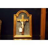 A circa 1880 carved ivory figures of Christ on a gilt painted cross in arch top frame