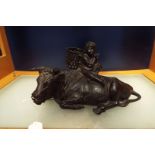 A 19thC Chinese bronze model of a recumbent Oxen mounted with seated child with basket and sickle