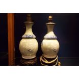 A pair of celadon lamps with blue and white collars and floral and insect decoration,