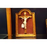 A circa 1870 carved ivory figure of Christ on a gilt painted cross in arch top frame