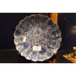 An oriental blue and white scalloped plate having floral decoration with symbols to under side