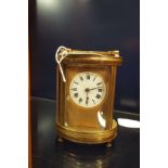 A circa 1900's brass and glass oval shaped carriage clock the dial with Roman numerals (needs