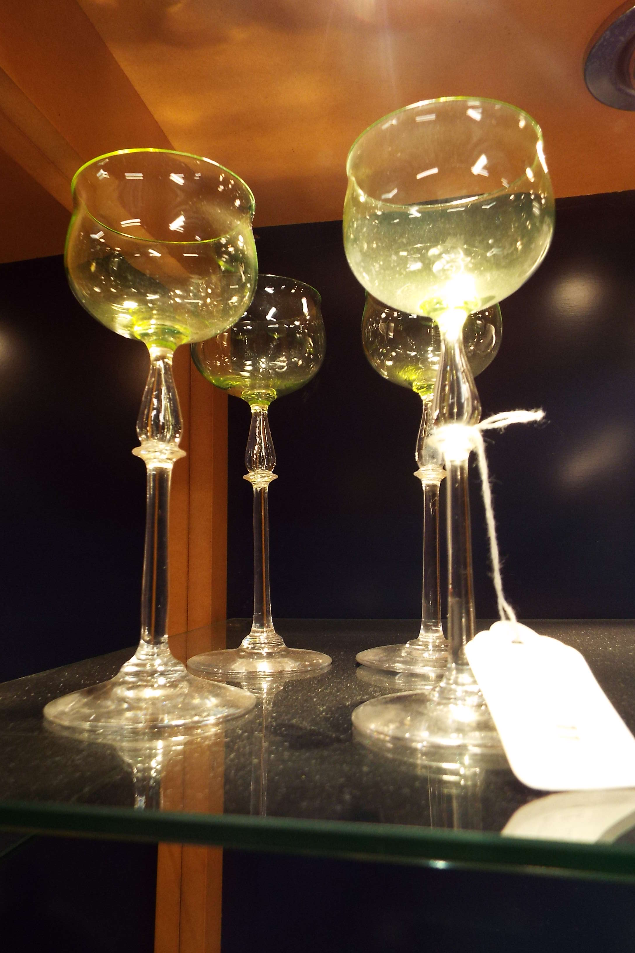 A set of four Edwardian uranium green glasses having teardrop pedestal stems