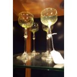 A set of four Edwardian uranium green glasses having teardrop pedestal stems