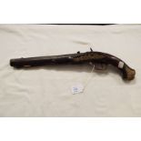 A circa 1820's percussion pistol having carved walnut stock and grip the barrel with stylised