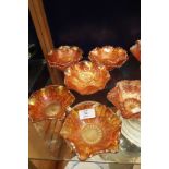 Nine carnival glass dishes with fluted rims some with floral decoration