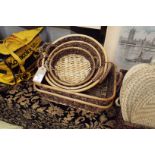 A set of three wicker baskets and two wicker tray baskets as new