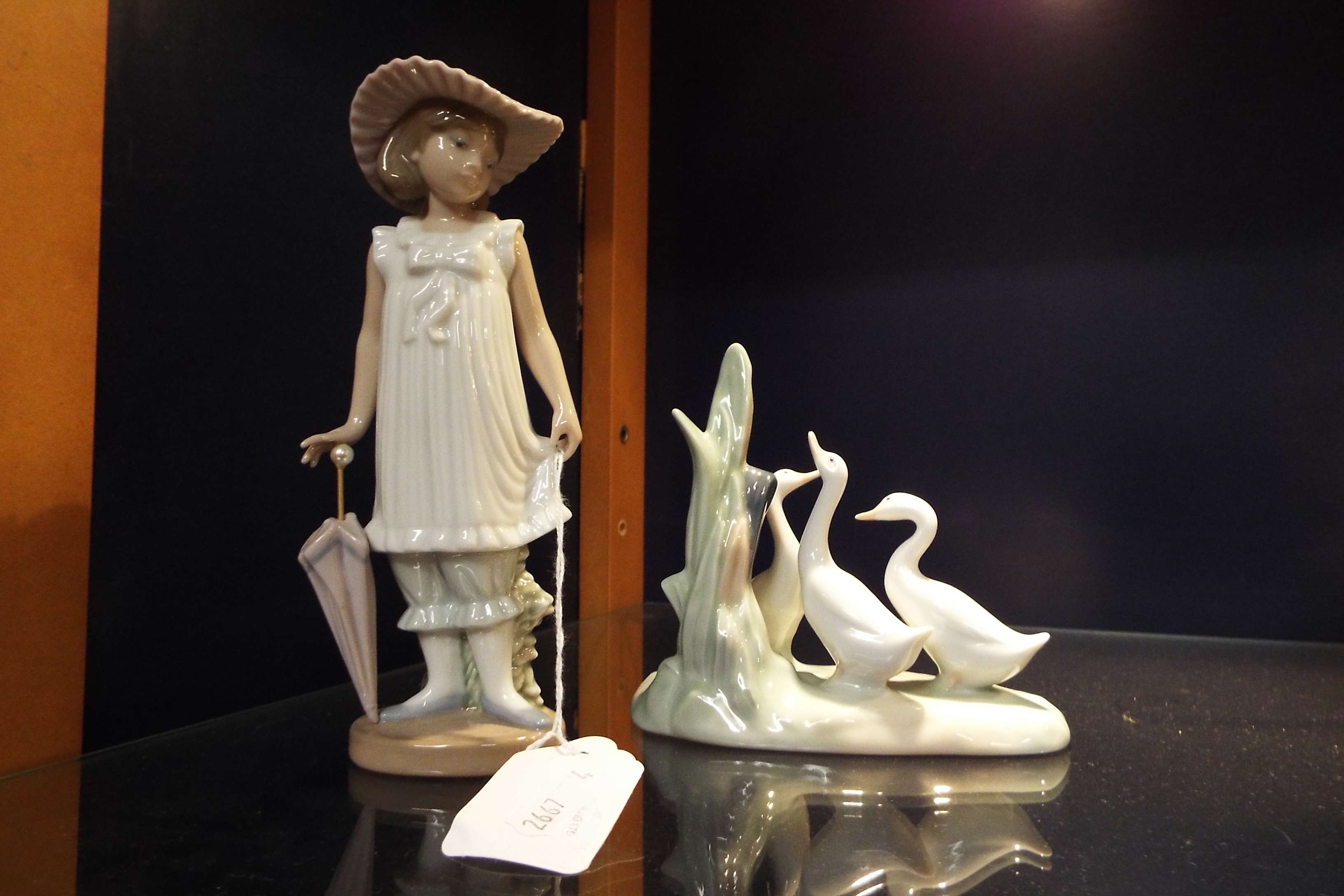 A Nao figurine of a girl with a parasol and a group of geese