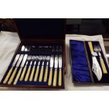 A boxed set of twelve silver-plated and bone handled fish cutlery with ornate engraving and a boxed