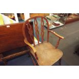 An early 20thC elm wheel back open armchair with solid seat,