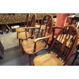 A set of mid-20thC elm hoop and spindle back dining chairs with solid seat and raised on turned