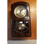 A mid-20thC walnut cased wall clock with silvered dial,