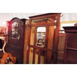 A mid-20thC oak hall stand with slatted back with central octagonal mirror over a hinged seat,