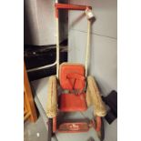 A 1950's childs tin-plate push along chair with rocking action possibly by Mobo