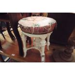 An early 20thC circular piano stool raised on floral carved tapering supports