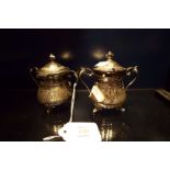 A pair of French silver mustard pots having scrolled handles the engraved body with cartouche