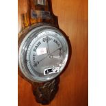 A 1940s oak cased aneroid barometer with silvered dial and thermometer above, presented to 'B.
