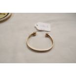 A 9ct gold bangle with ball ends 11.