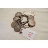 A silver charm bracelet with charms and coins