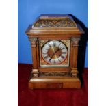 Carved walnut cased mantel clock, brass and steel face with brass presentation plaque,