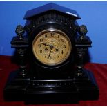 Victorian black slate mantel clock with arched pediment and twin Corinthian columns with cast