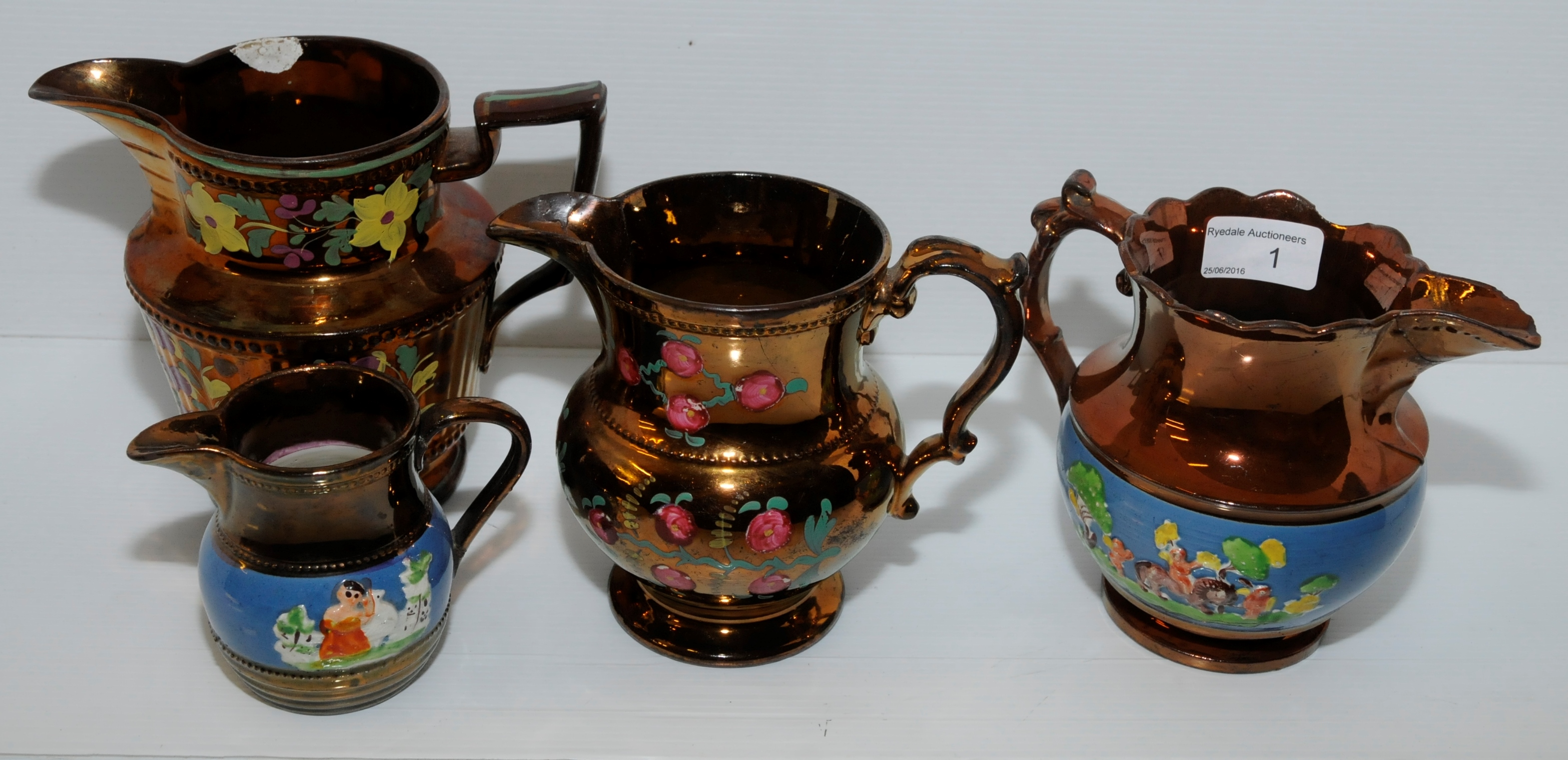 Four copper lustre jugs with enamel painted decoration