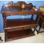 Oak three tier buffet with raised carved back and two drawers on turned supports