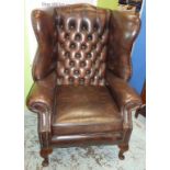 Large leather wing back Chesterfield style armchair on cabriolet supports