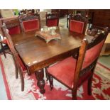 Oak extending dining table on carved supports and a set of 5 carved and upholstered dining chairs