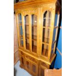 Modern break front display cabinet with upper glazed door above single cupboard door