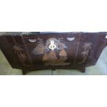 Lacquered effect chest with carved detail depicting ships and palm trees