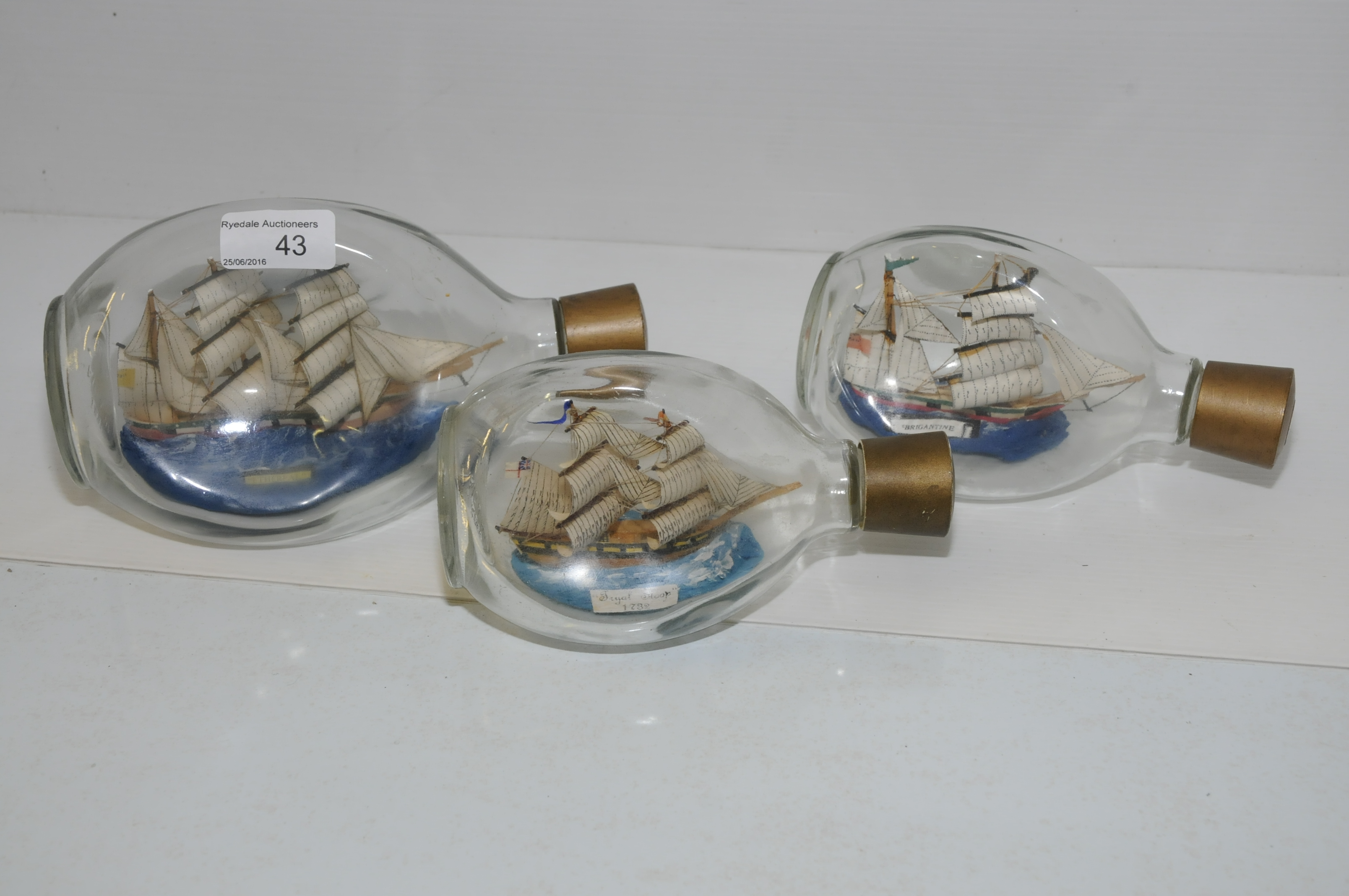 Three glass ships in bottles