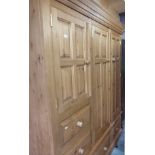 Large combination wardrobe with two panelled cupboard doors above two drawers flanked by a further