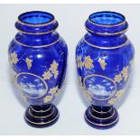 Pair of Victorian blue glass vases with hand painted enamel panels depicting woodland cottage and