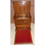 Oak stationary box with fall front revealing sectional top above two pull out drawers,