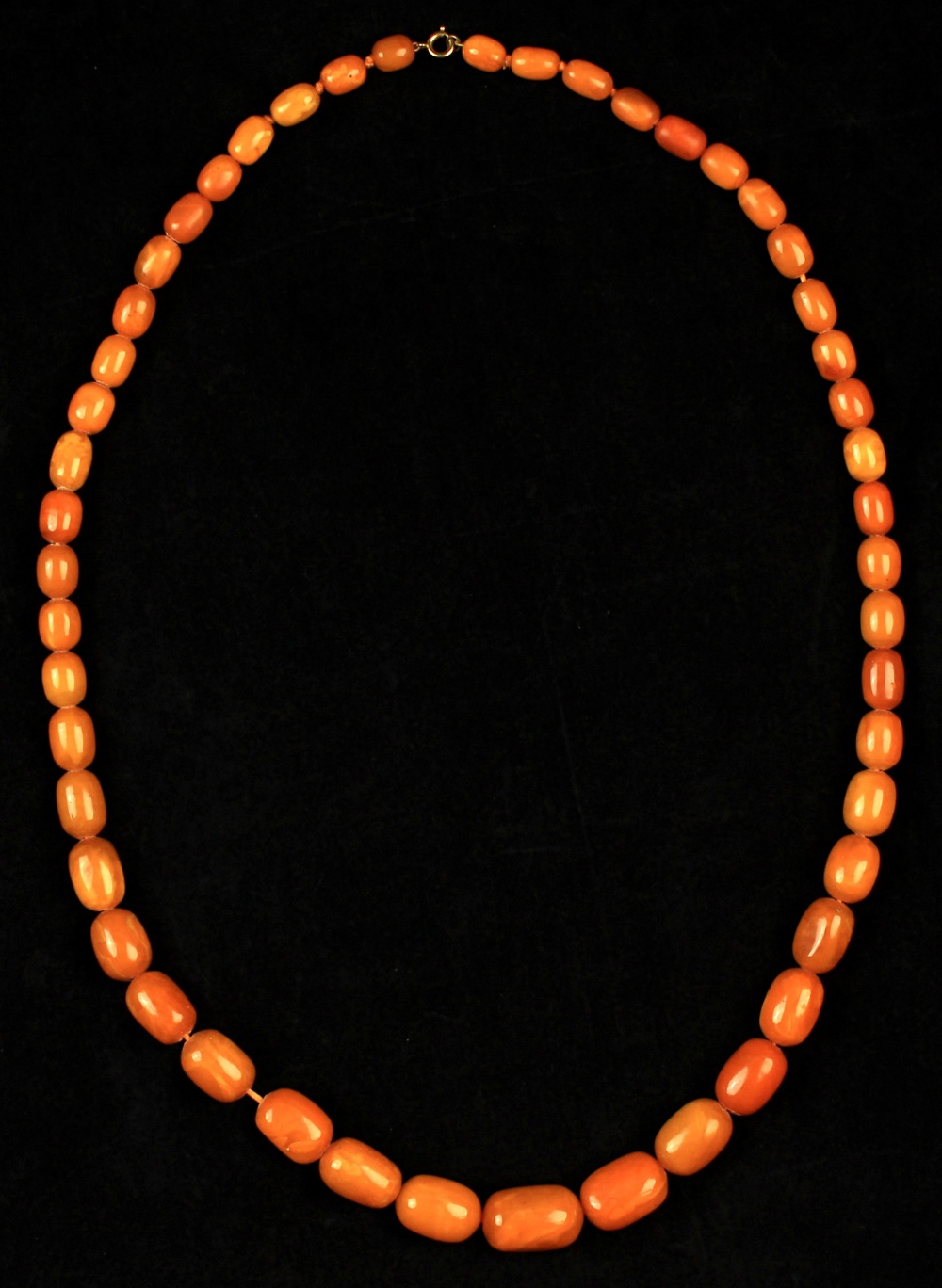 Property of a lady - a butterscotch amber graduated bead necklace, the 49 beads ranging from 13mm to