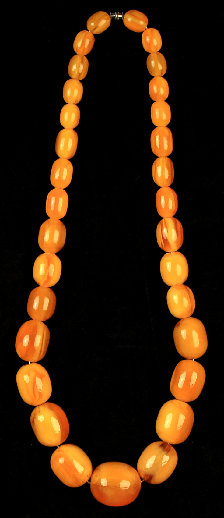 Property of a lady - a butterscotch amber graduated bead necklace, the 31 beads ranging from 15mm to