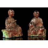 A pair of Chinese carved hardwood figures of seated Lohan, 18th century, one modelled holding a bead