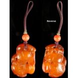 A 19th century Chinese carved amber pendant modelled as fruit on a branch, on short cord with