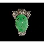 An Art Deco style 18ct white gold carved jadeite & diamond clip, the shaped oval jadeite panel