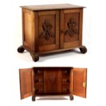 Property of a deceased estate - a carved oak table cabinet with two doors enclosing drawers with